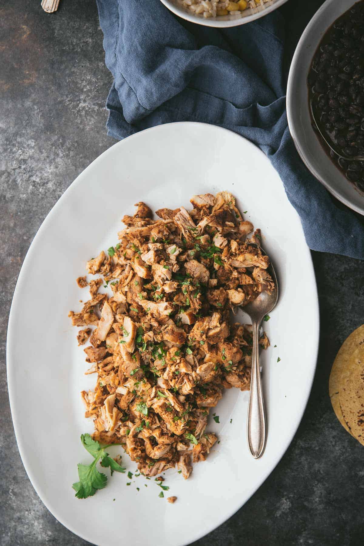 platter of chipotle chicken thighs with a spoon