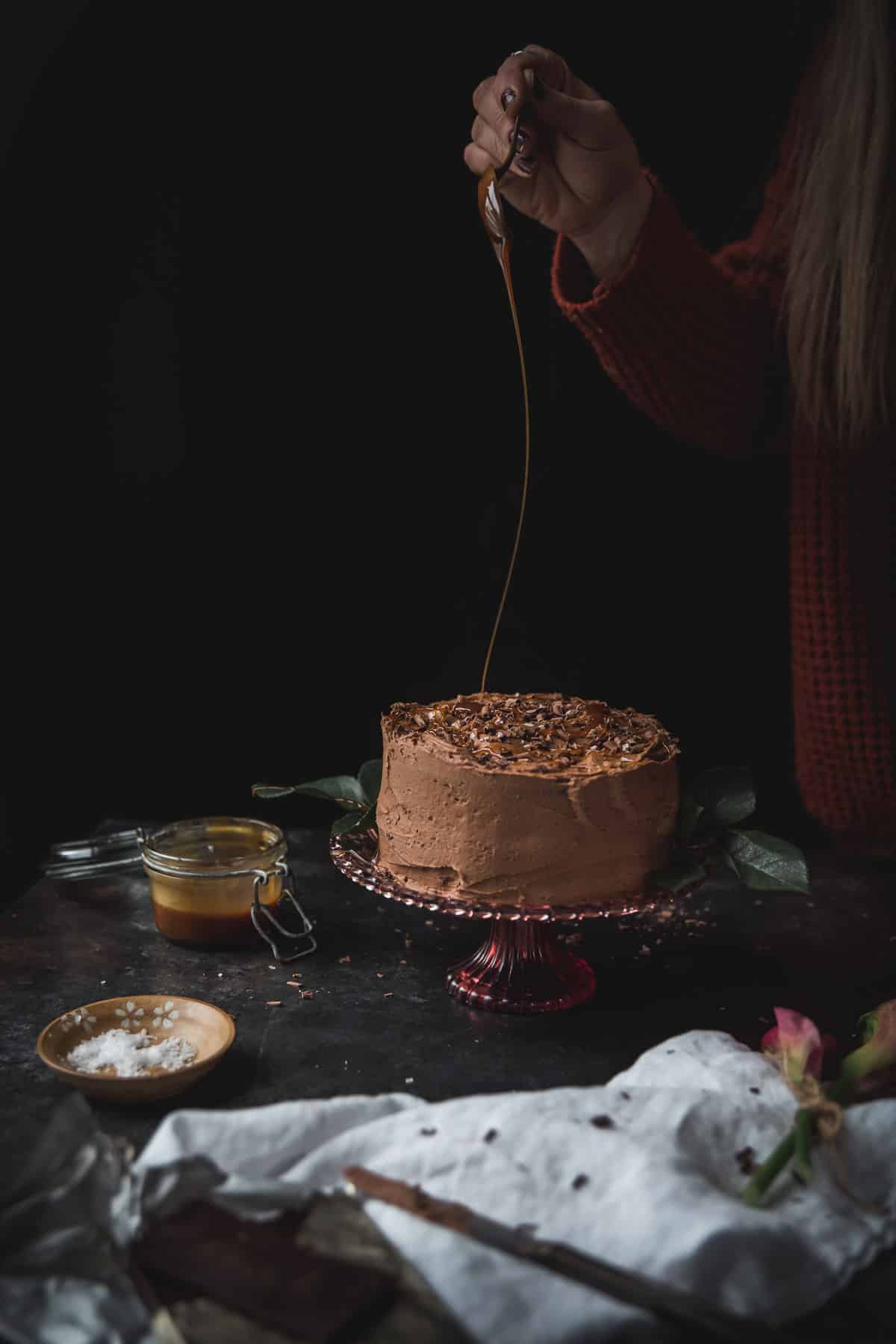 swirling chocolate over a cake