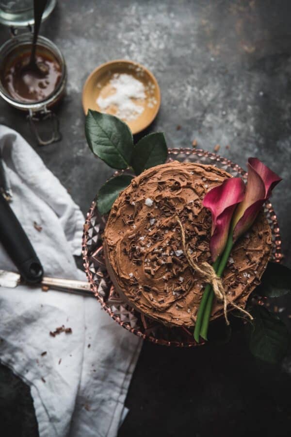 overhead shot of chocolate cake topped with flowers and chocolate shavings