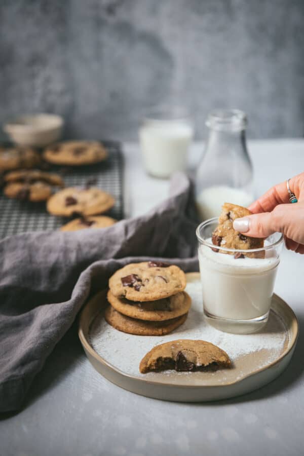 dipping cookie into a glass of milk