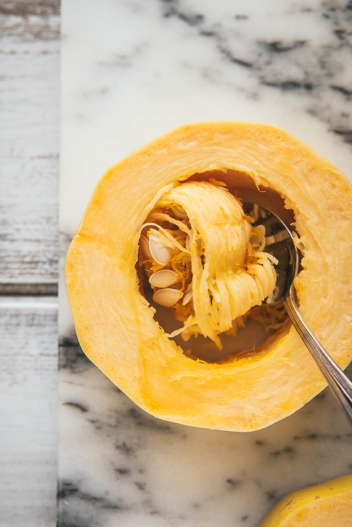 scooping out the seeds of a spaghetti squash