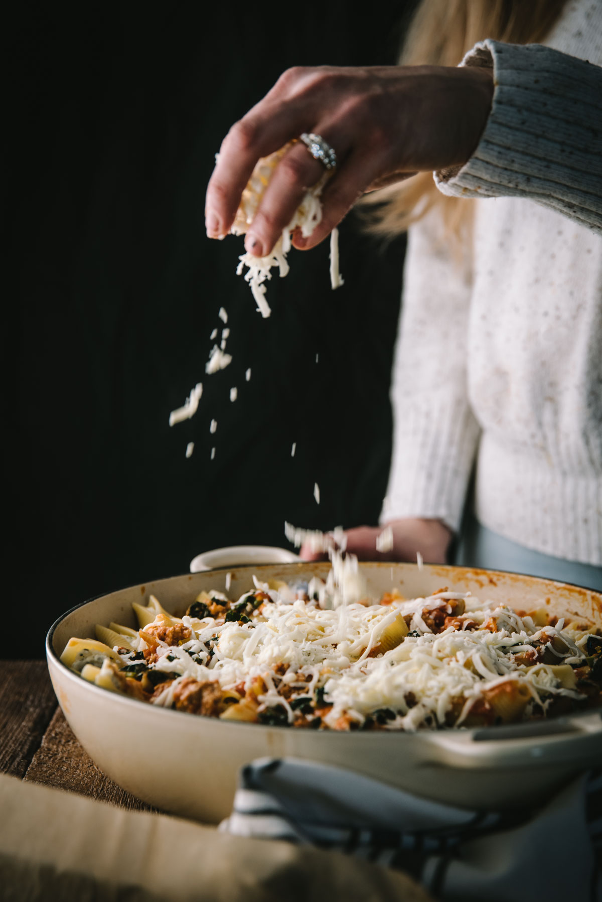 sprinkling cheese over a dish 