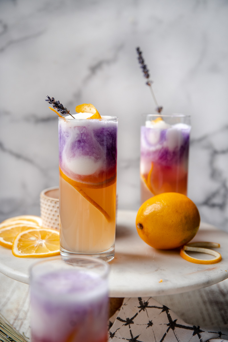 Layered drinks with lemon, purple gin, and lemon sorbet.