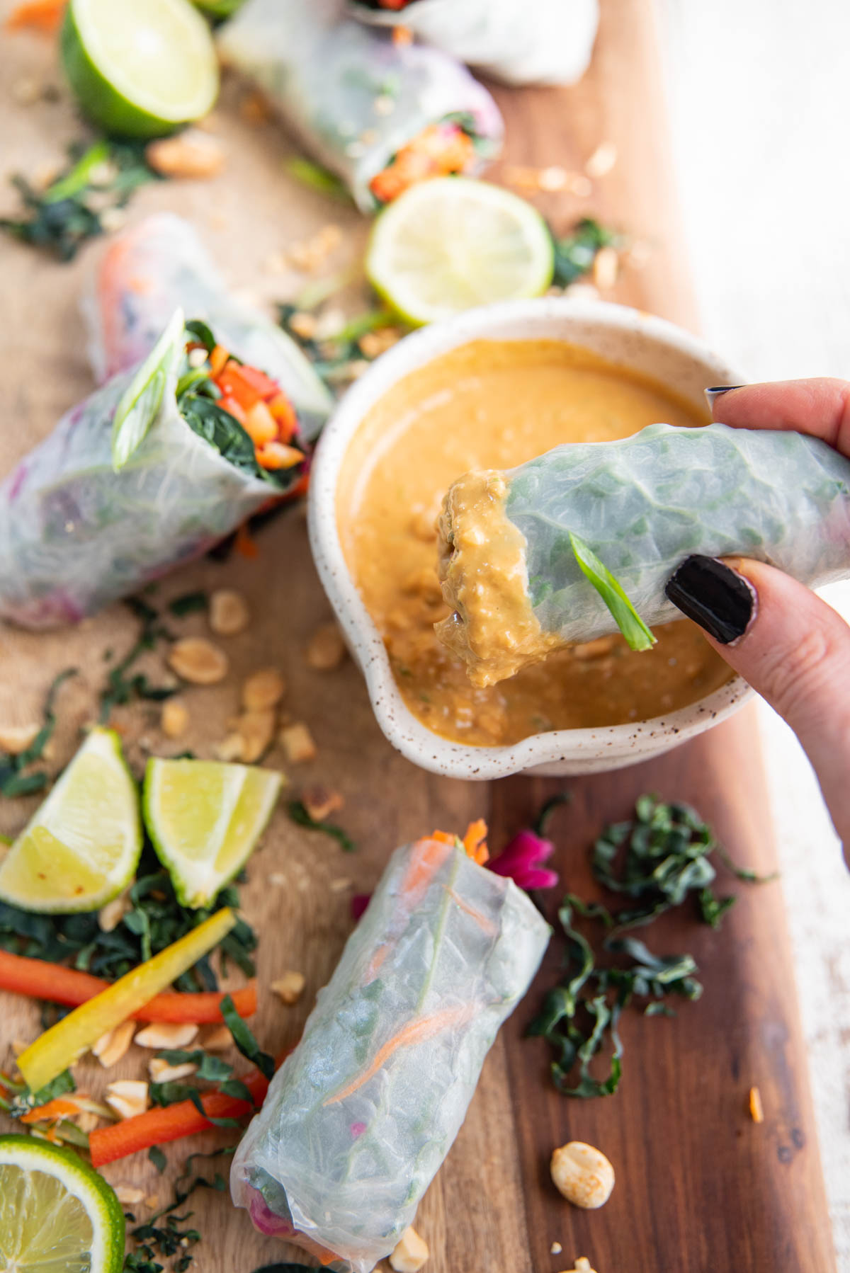 dipping veggie spring roll into thai peanut sauce