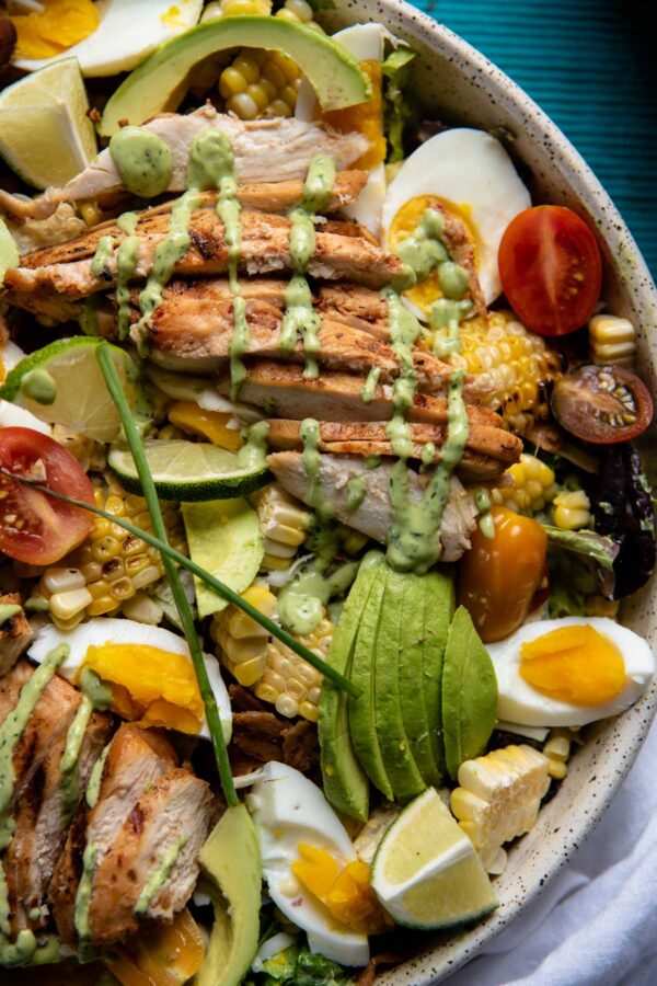 close up of salad with avocado, chicken, eggs, cherry tomatoes