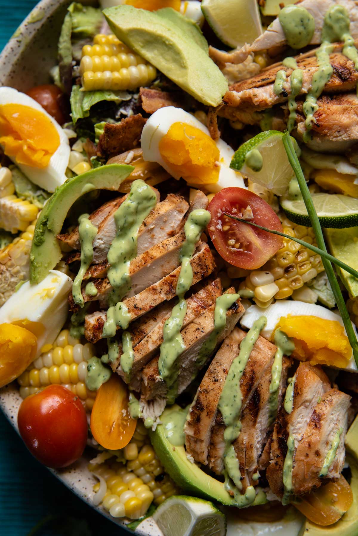 close up of salad with avocado, chicken, eggs, cherry tomatoes