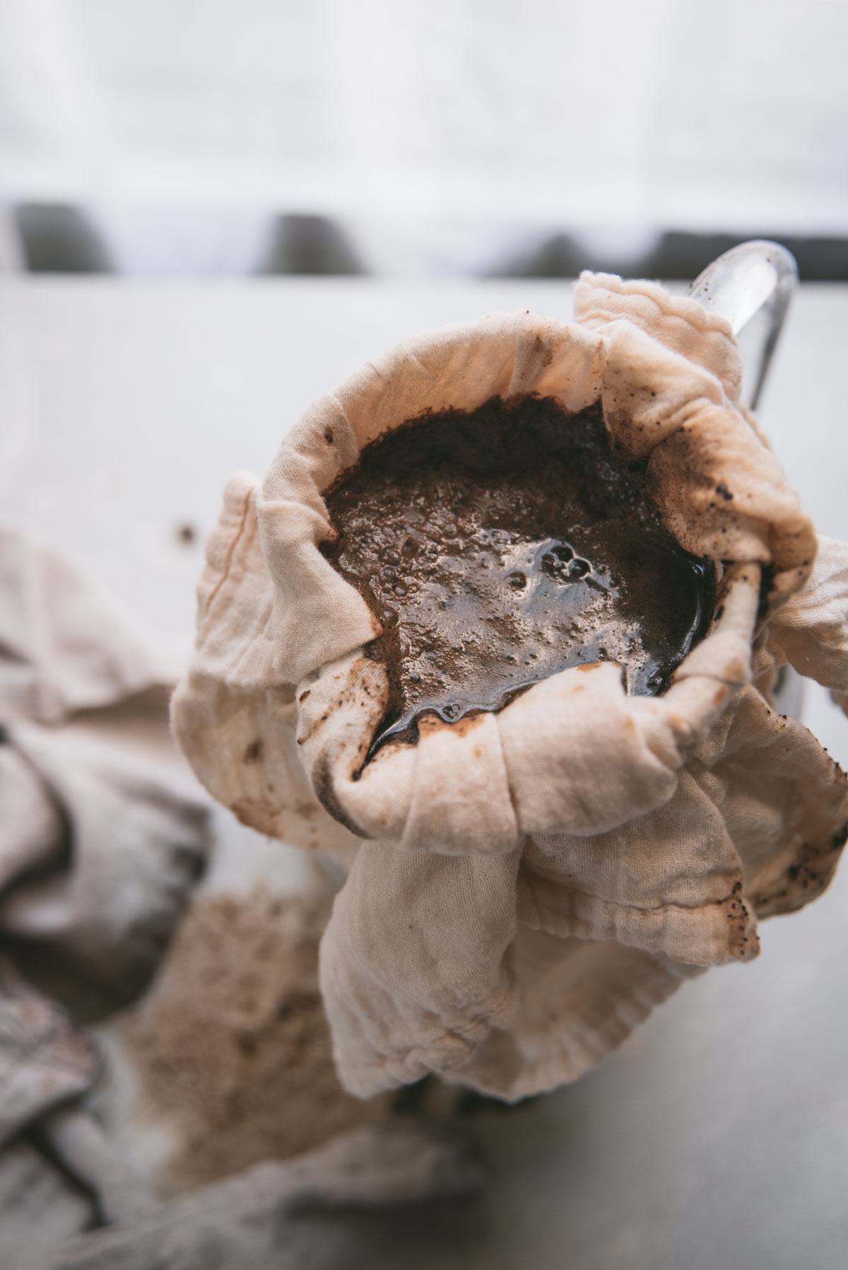 coffee grounds straining through cheesecloth