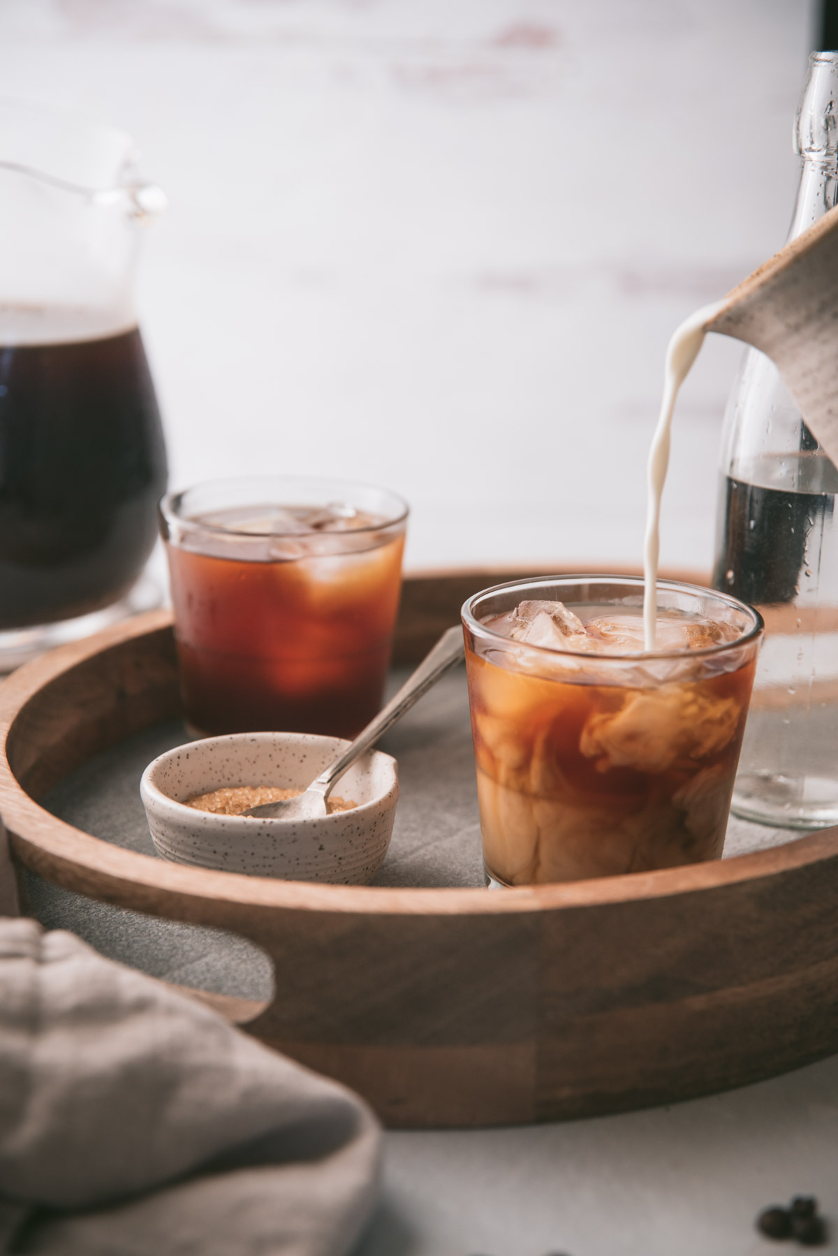 milk pouring into glasses of cold brew coffee