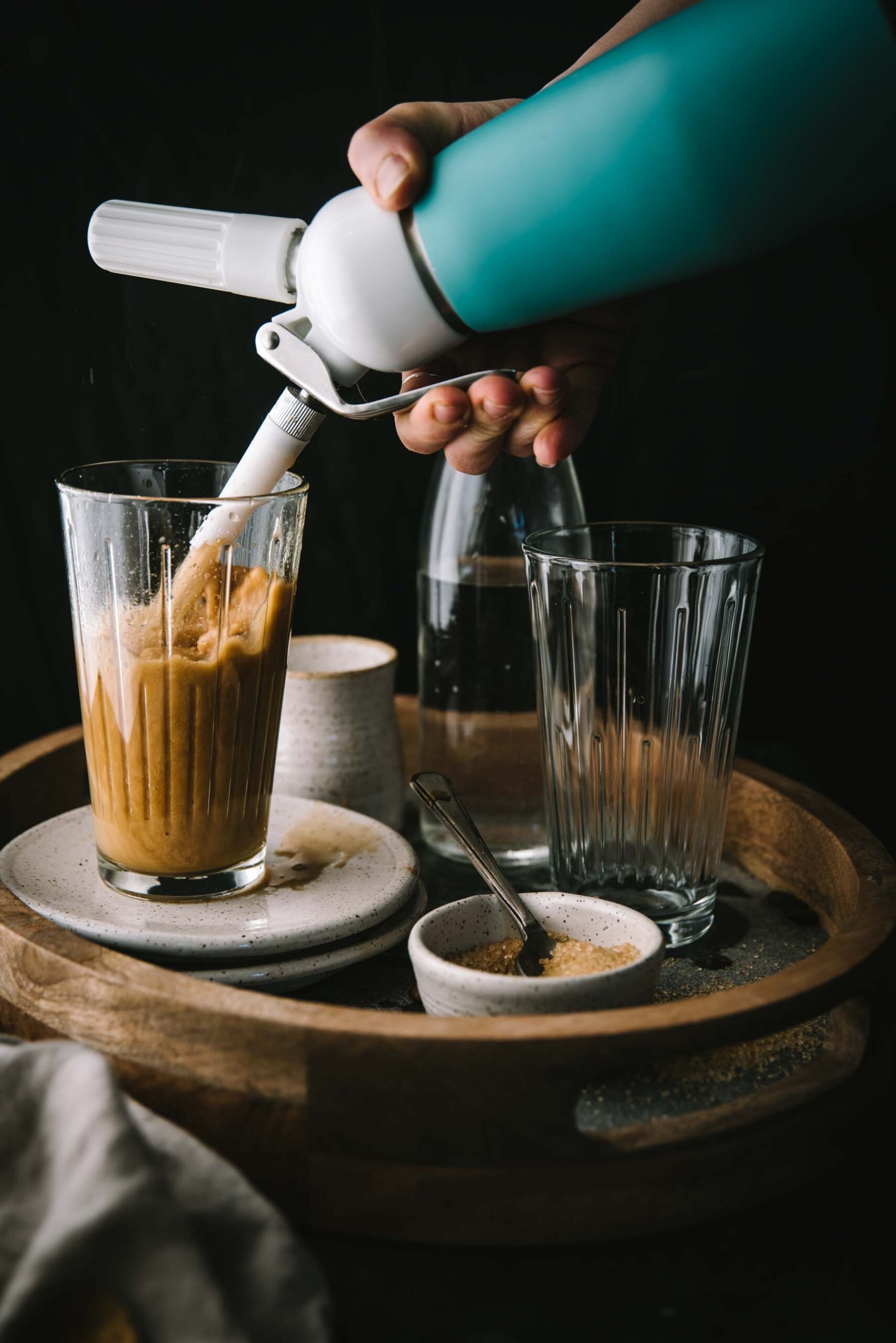 Cannister pouring nitro coffee into a glass