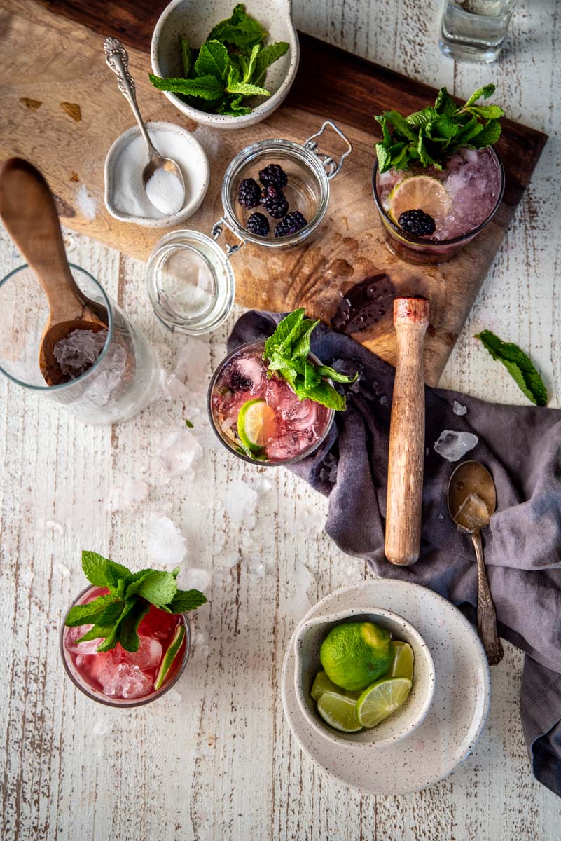 overhead of blackberry mojitos and the ingredients to make them