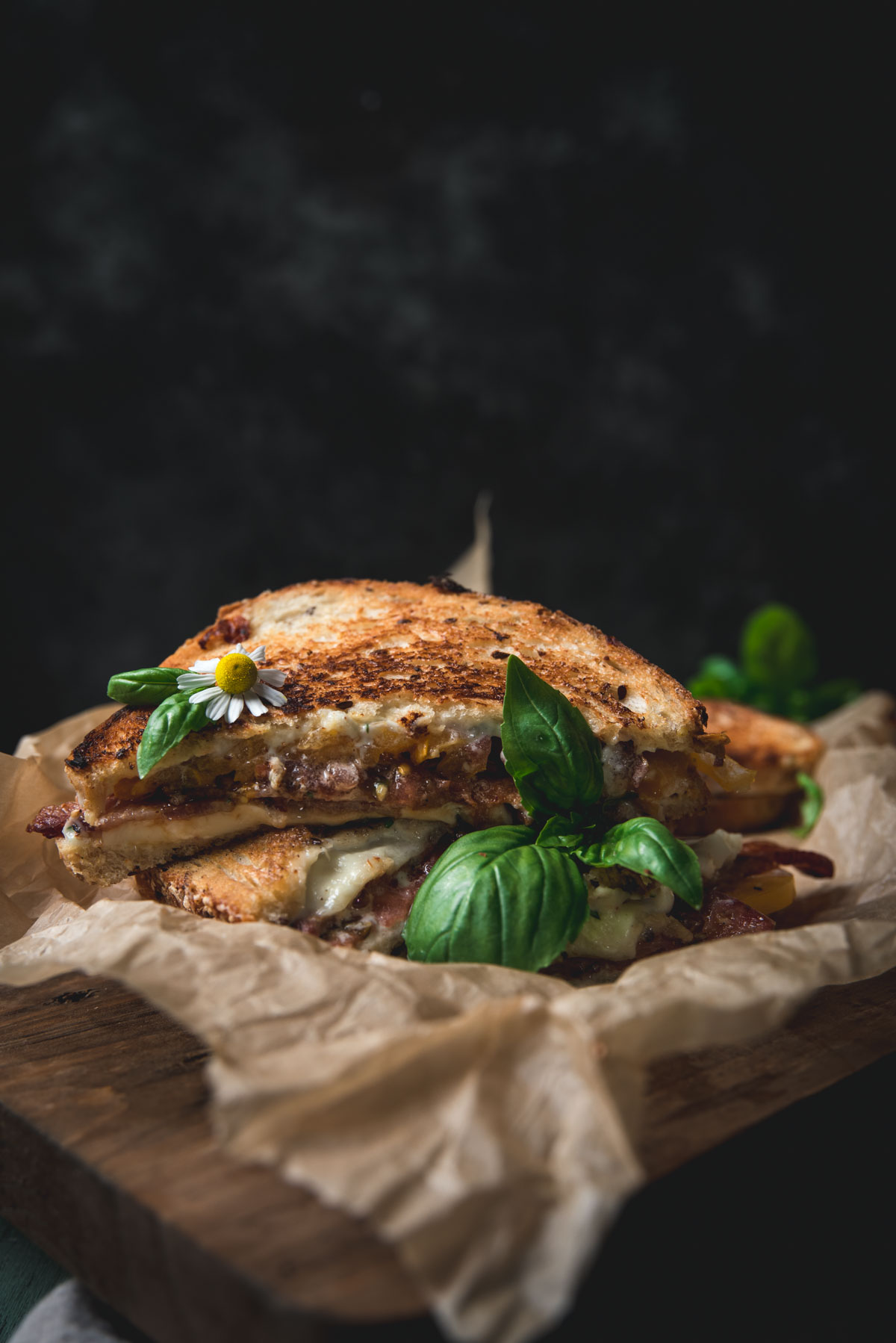 Stacked halves of BLT on parchment paper