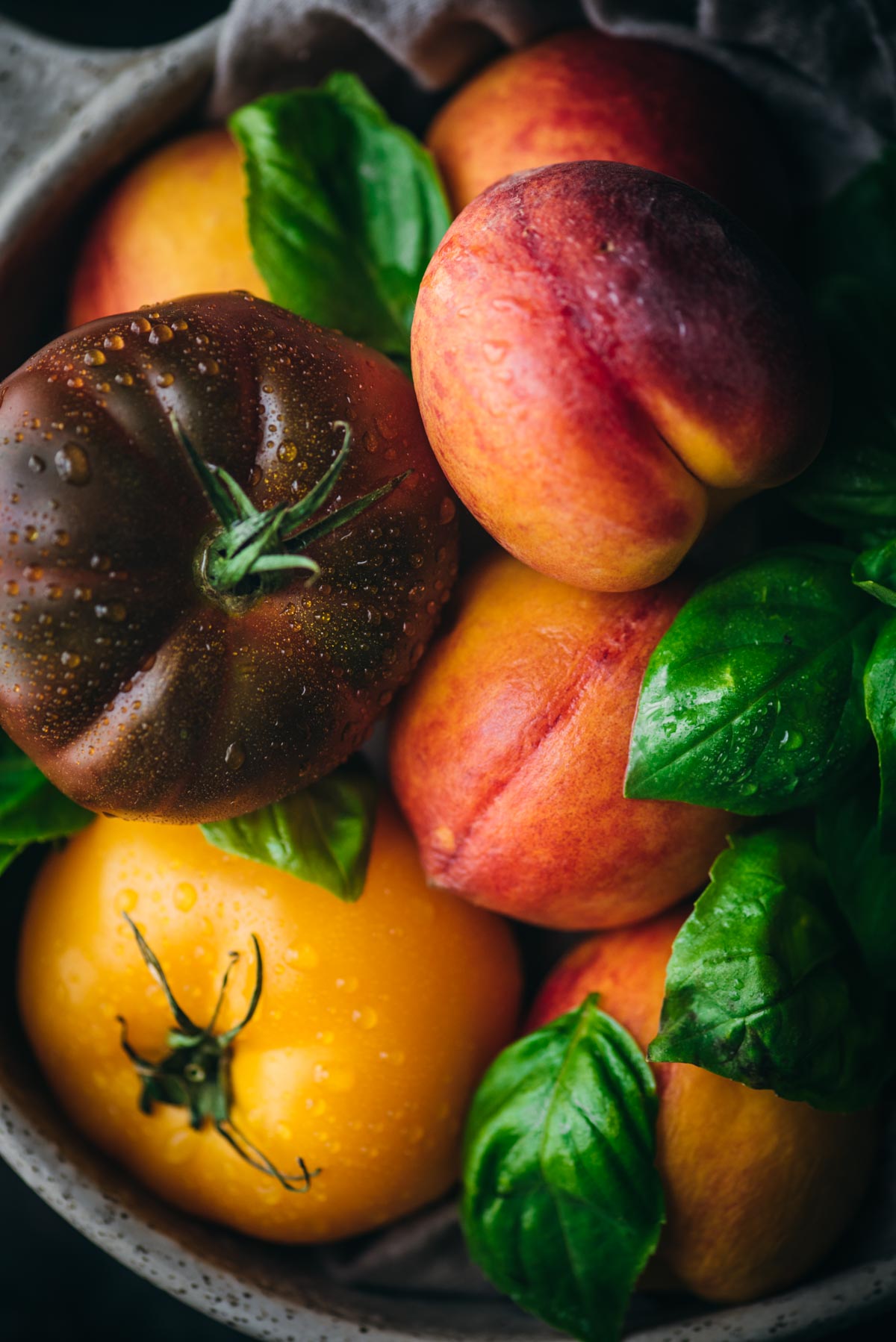 tomatoes peaches and basil in a bowl