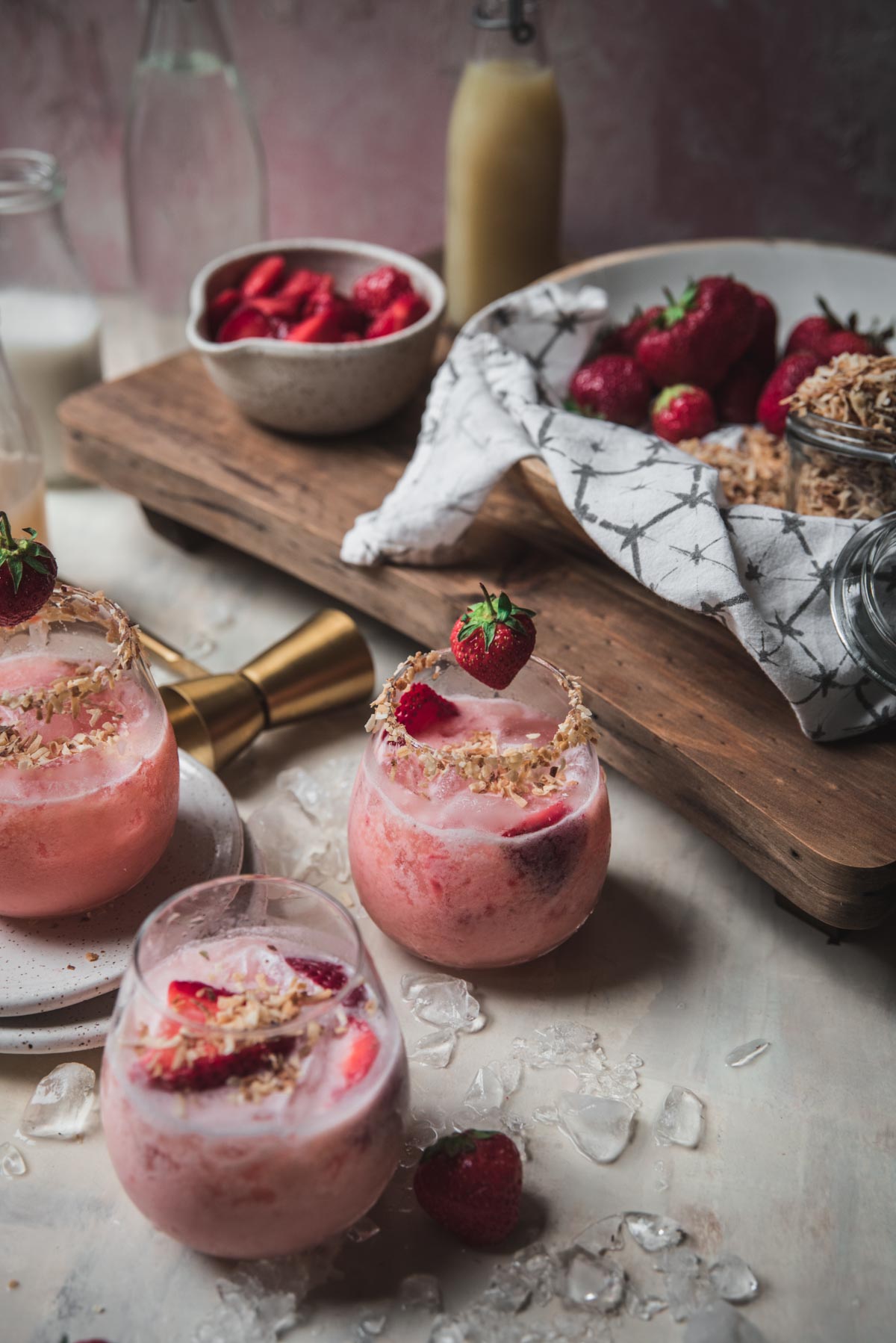 wine glasses filled with strawberry coconut margaritas with coconut rim