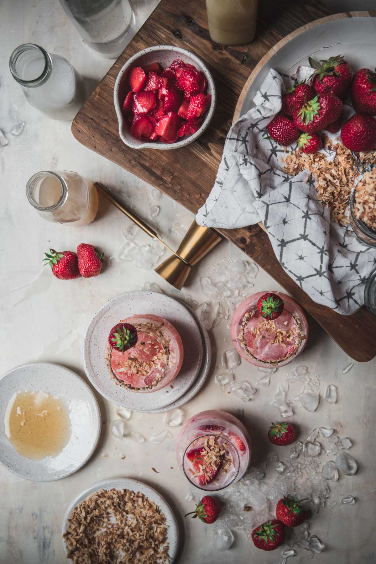 overhead image of strawberry infused cocktails with the ingredients scattered around