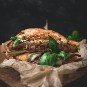 Stacked halves of BLT on parchment paper