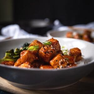 side angle of fried tofu in a bowl with spicy korean sauce