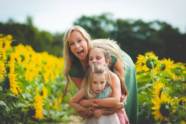 mom and two kids in a sunflower field