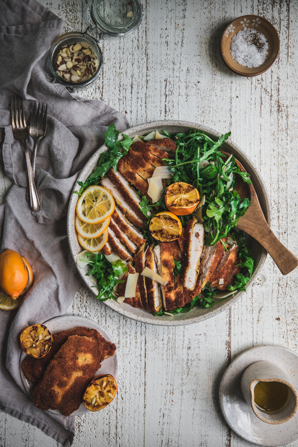 overhead photo of chicken milanese sliced over arugula salad