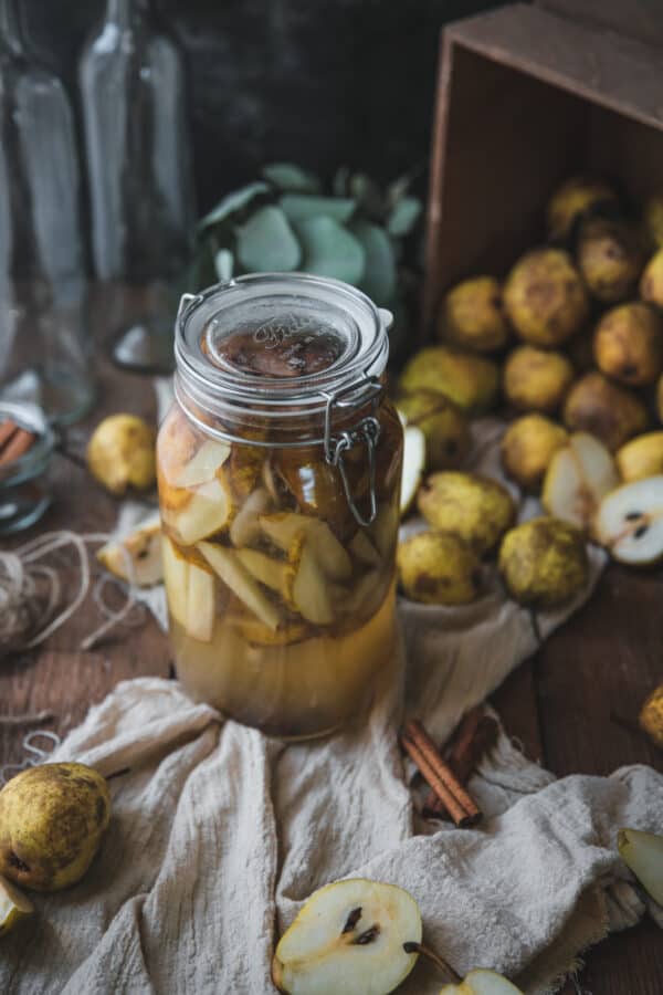 pear and cinnamon infusing into vodka in a large container