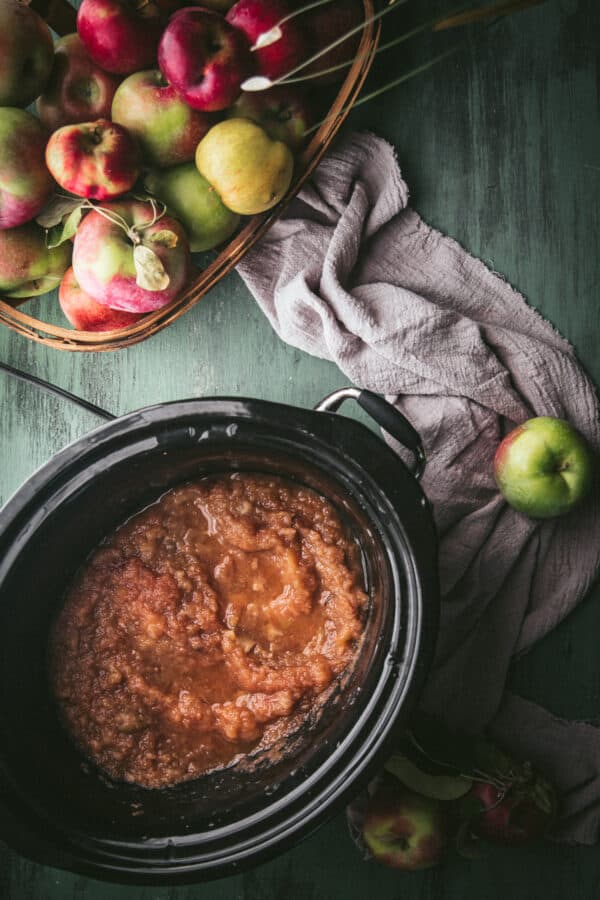 overhead of cooked apples stirring into a sauce texture in a crockpot