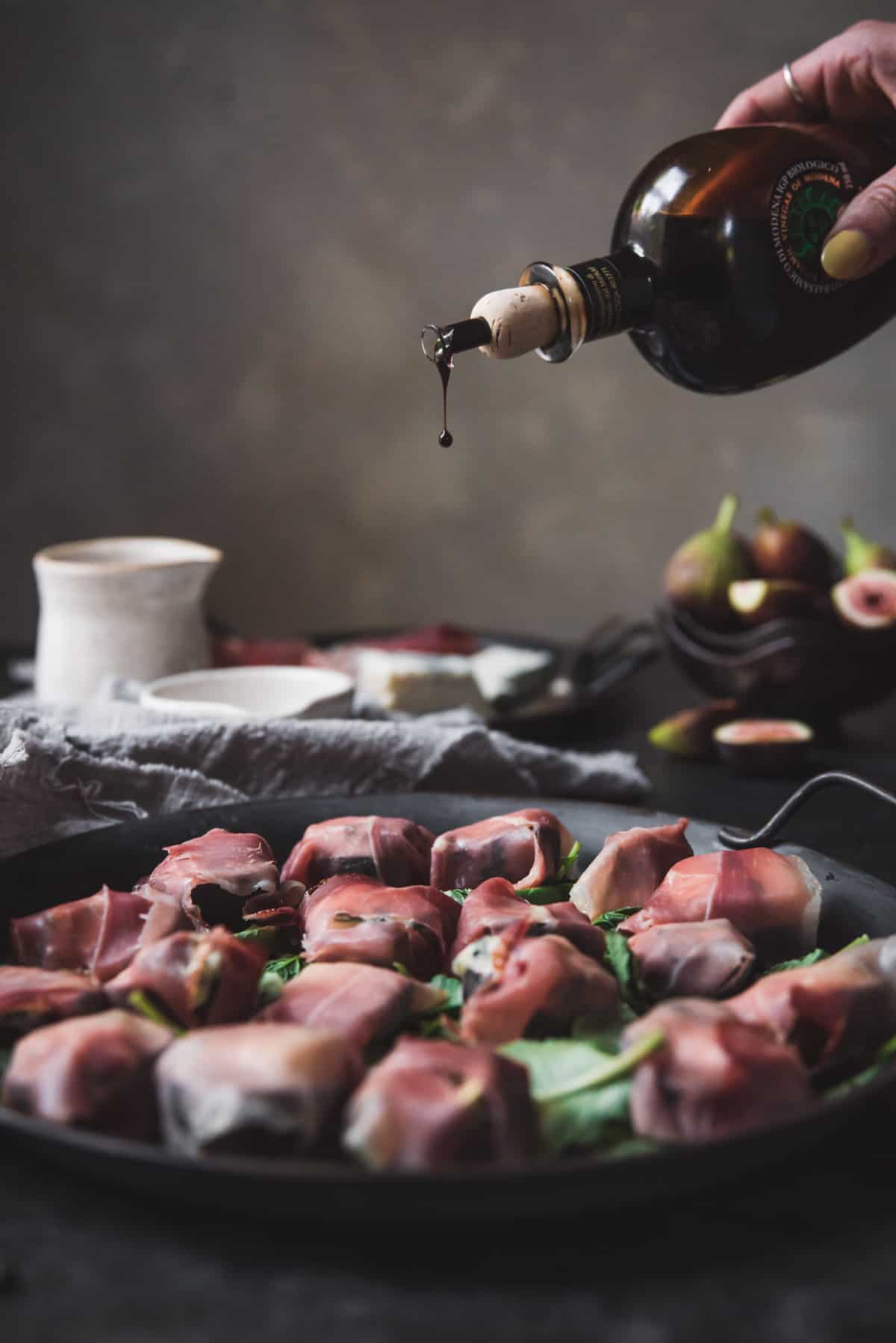 drizzling balsamic vinegar over figs