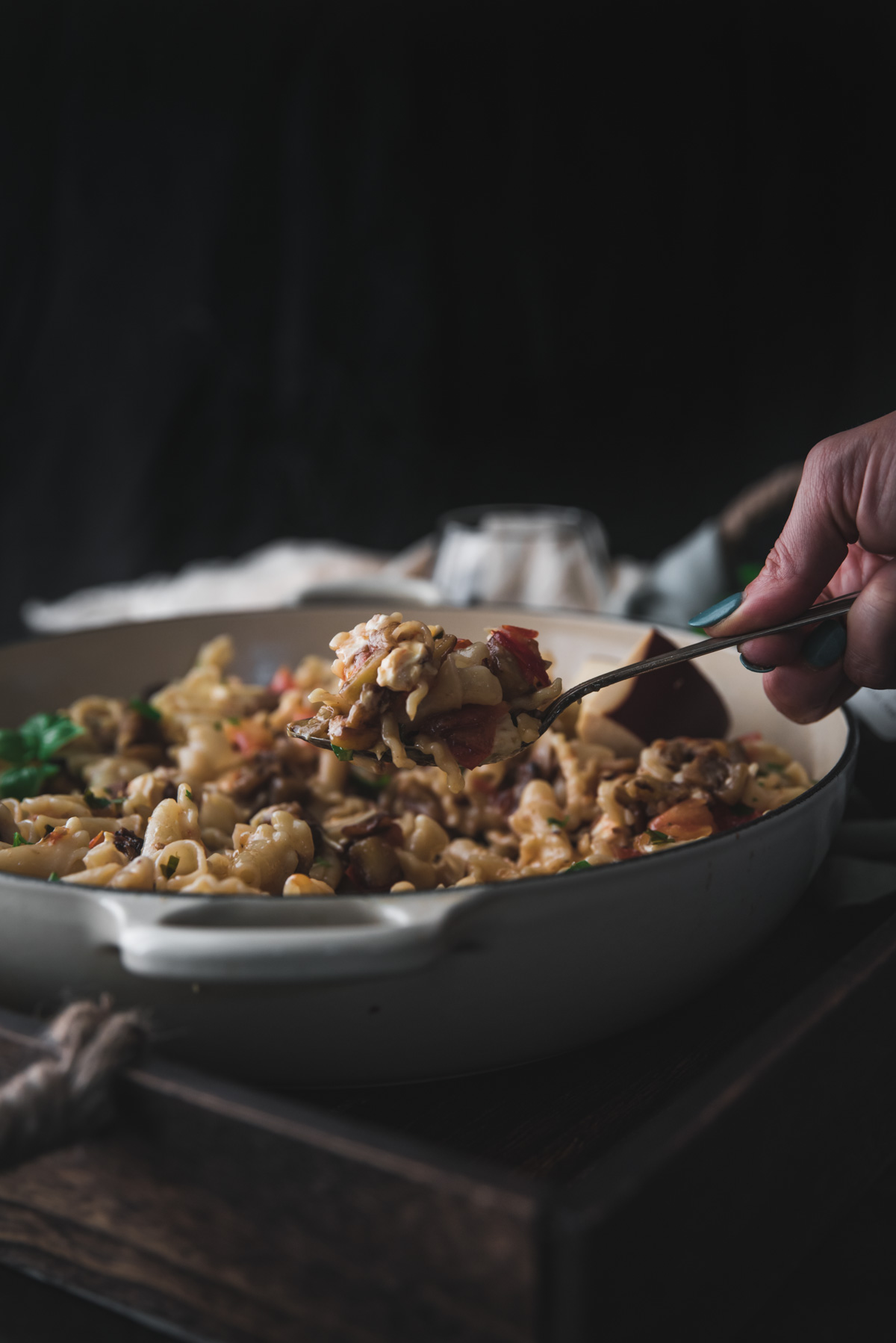 scooping cheesy pasta out of a dish