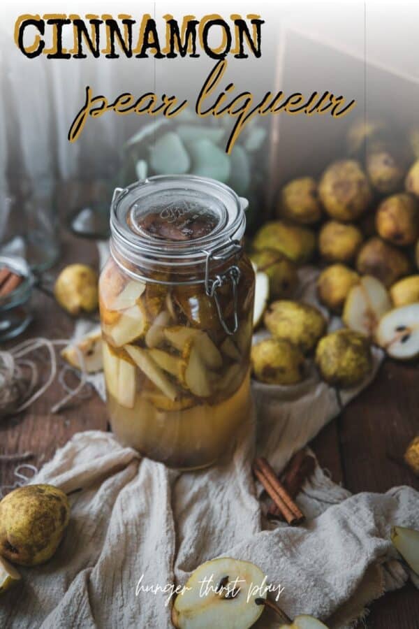 pear and cinnamon infusing into vodka in a large container