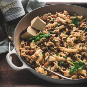 overhead photo of pasta with sauteed eggplant and fresh diced tomatoes with smoked cheese