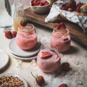 wine glasses filled with strawberry coconut margaritas with coconut rim