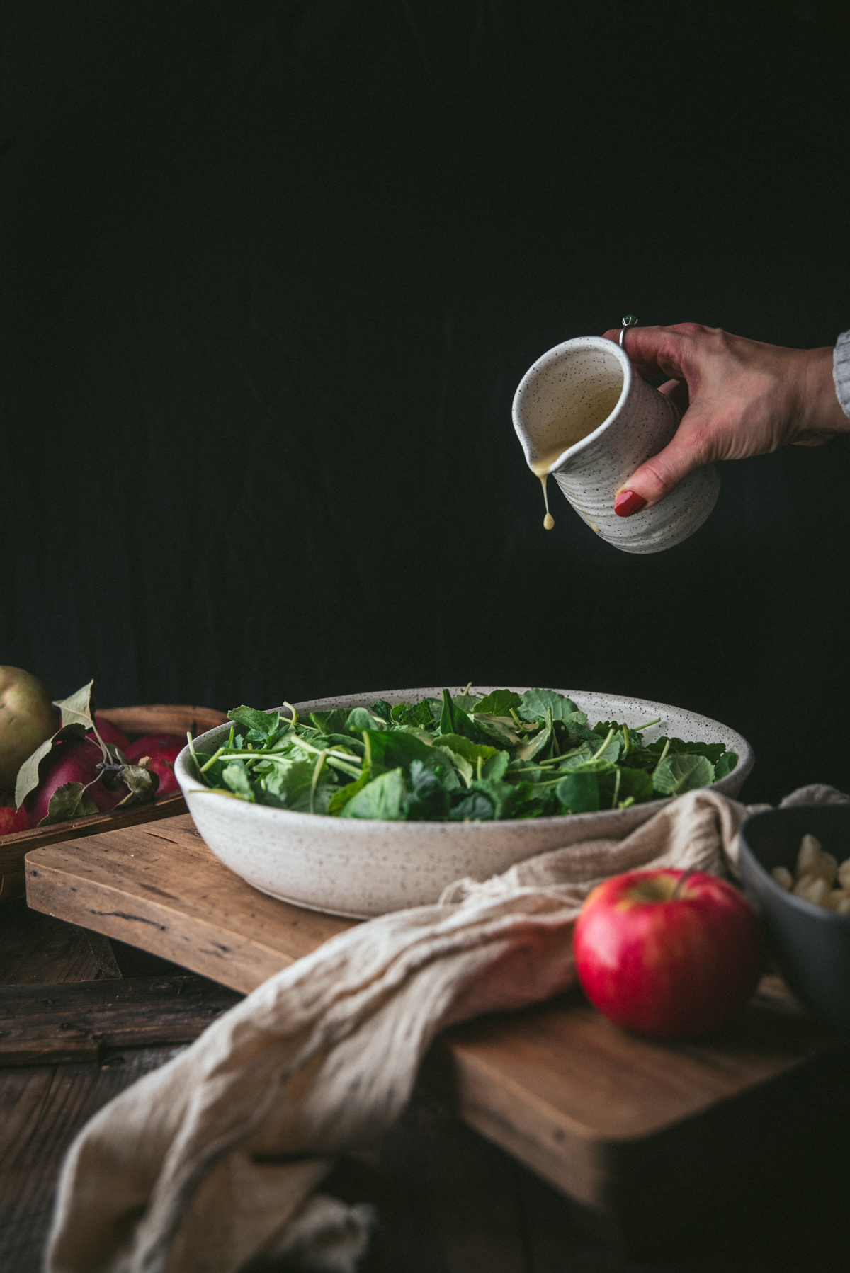 pouring dressing over salad greens