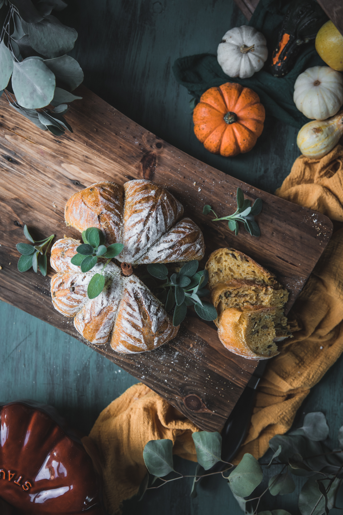 overhead of pumpkin shaped sourdough bread on a cutting board