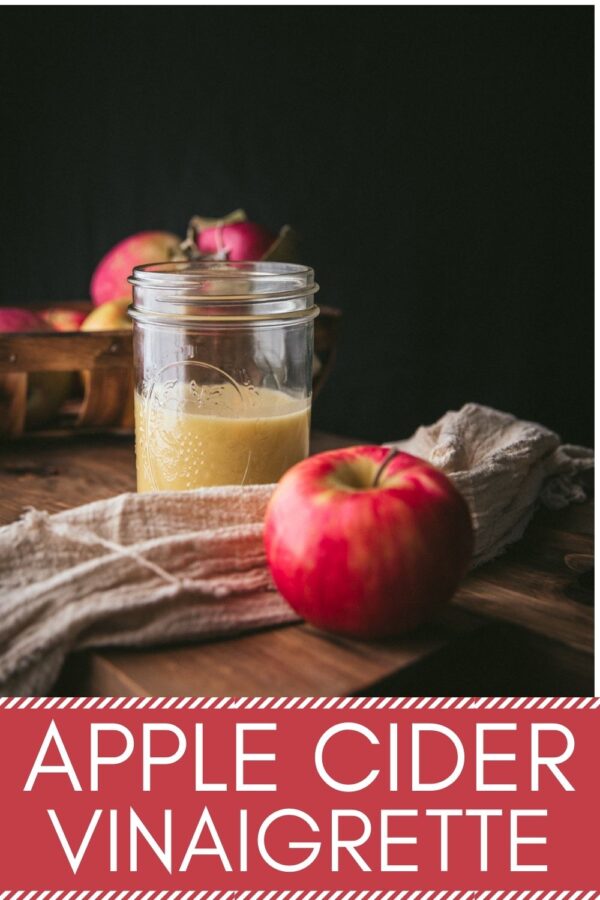 dressing in a mason jar with a red apple in front of the jar