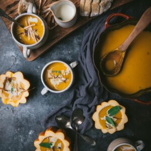 overhead of soup in a cast iron pot with small bowls of soup around it