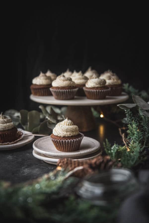 cupcakes on a platter with winter foliage in front