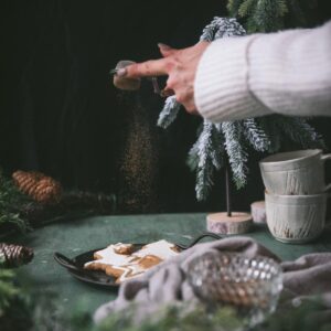 dusting gingerbread spice over cookies