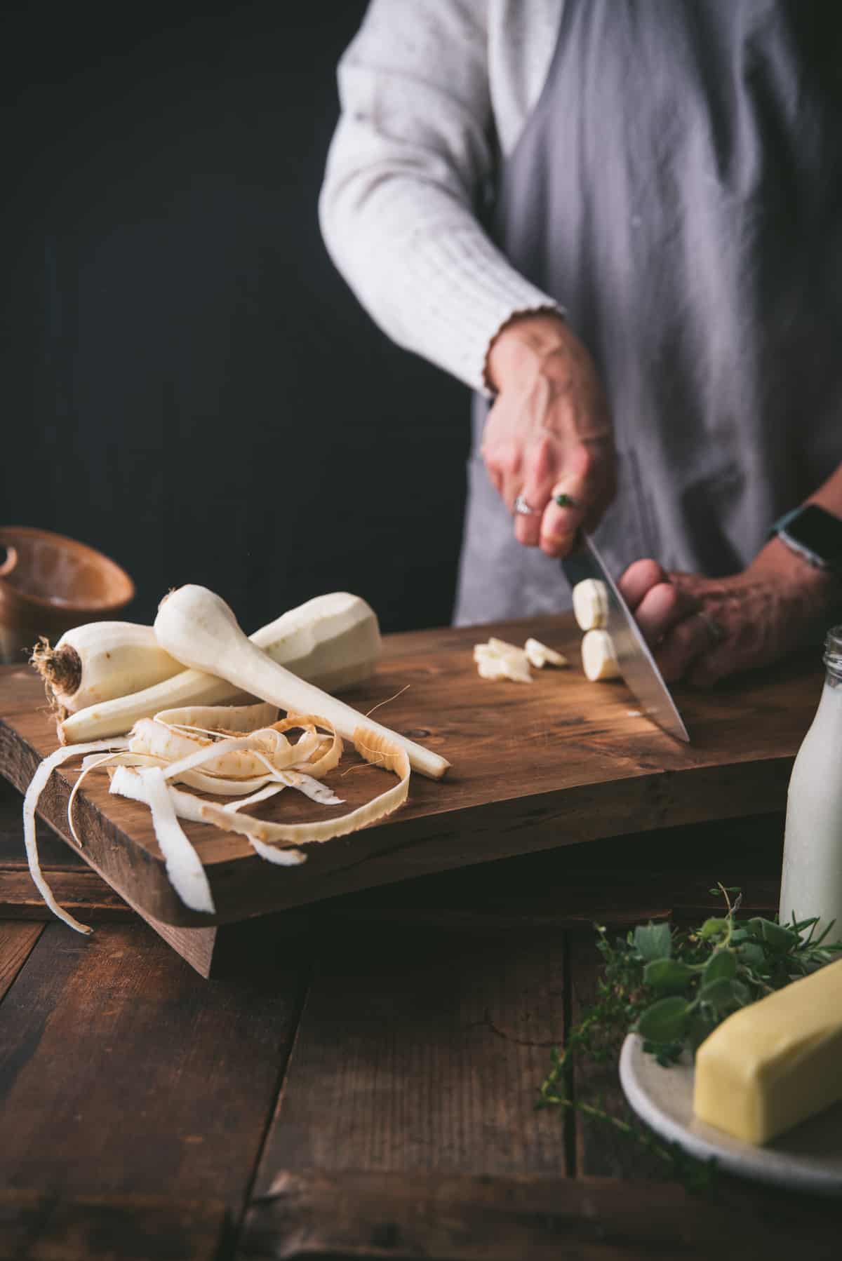 slicing peeled vegetables on a wooden cutting board