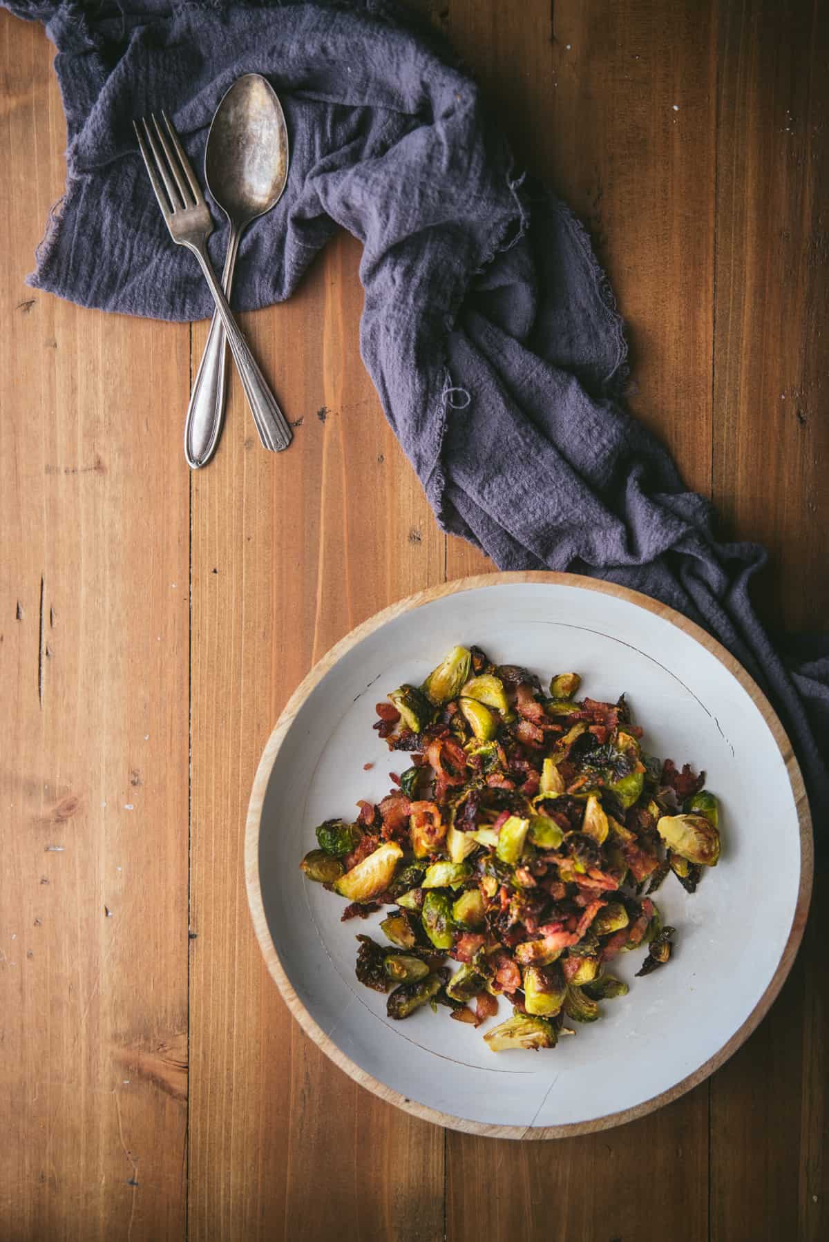 platter of roasted sprouts with linen napkin and utensils