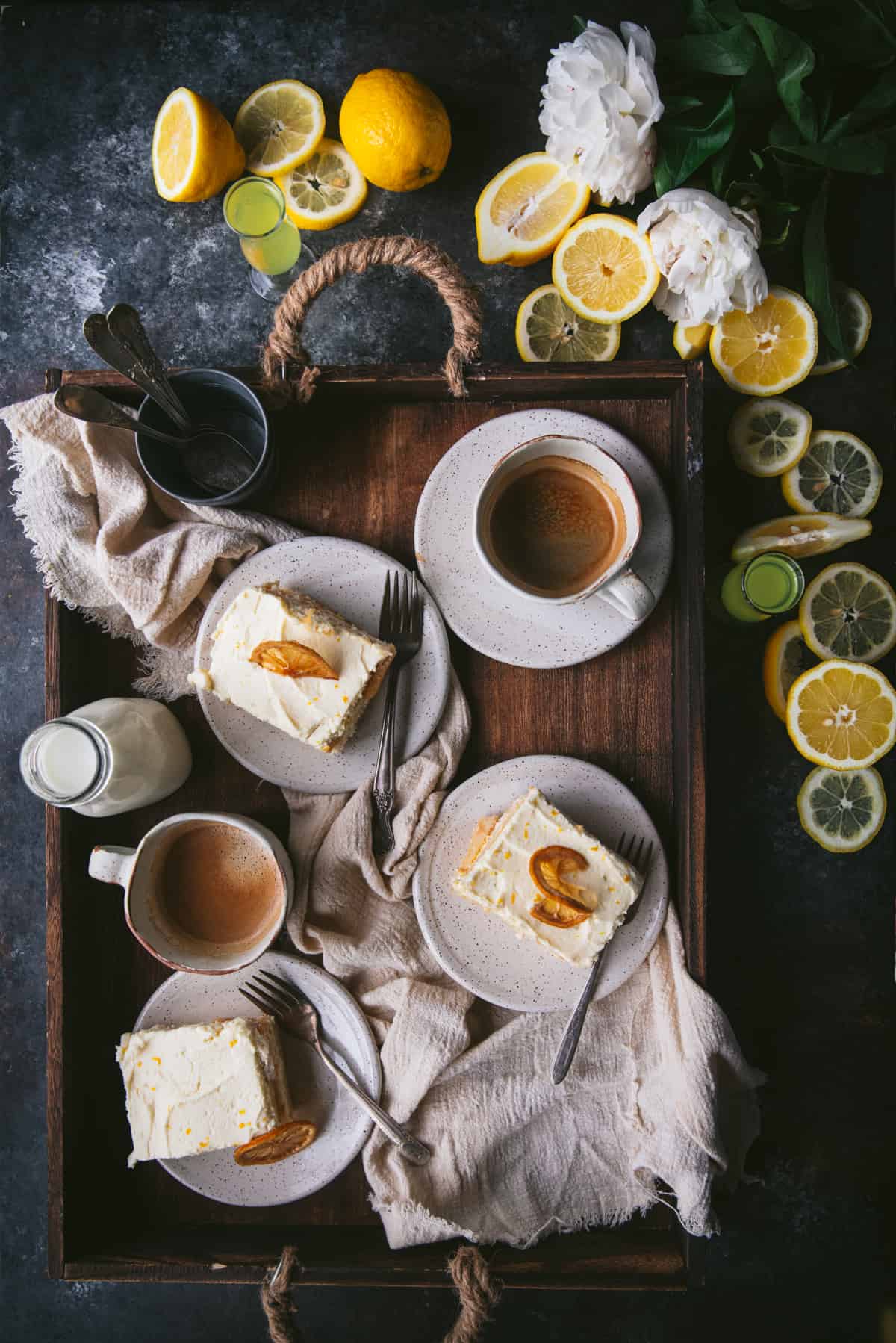 overhead of limoncello tiramisu on a serving tray with plates and coffee