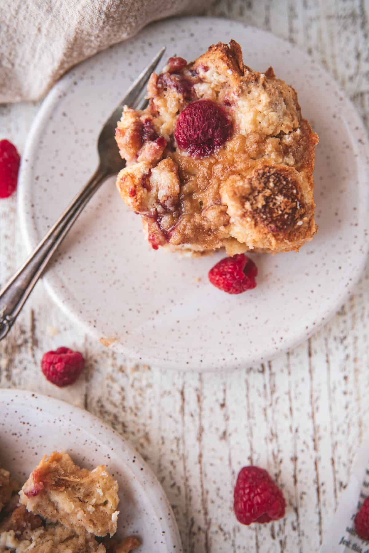 overhead close u of french toast bake on a plate with fresh berries and a fork