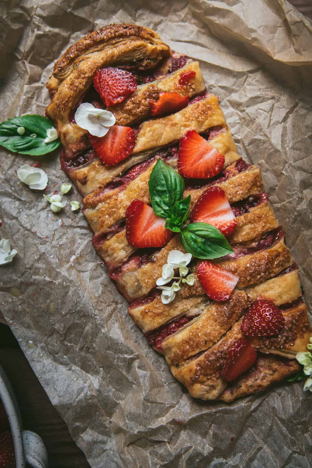 overhead photo of strawberry puff pastry braid on parchment paper
