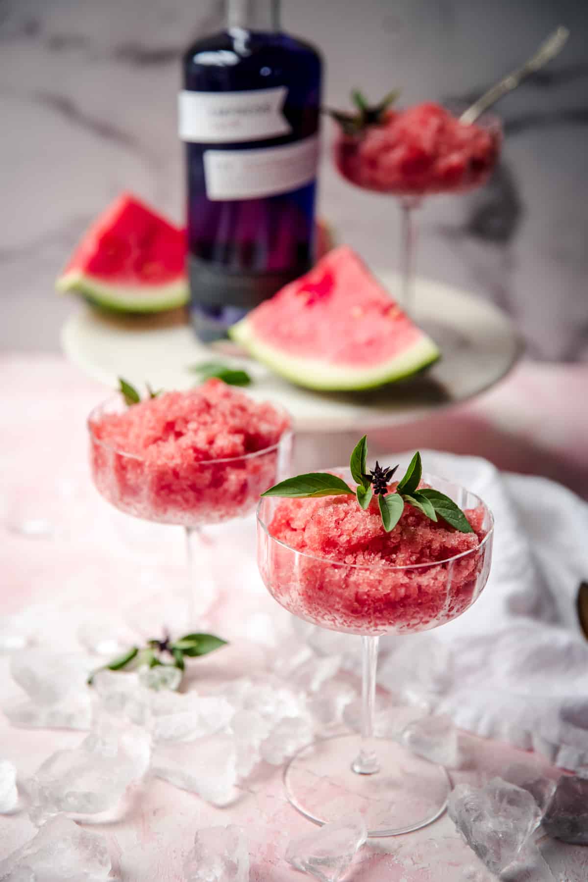 servings of granita in martini galsses with slices of watermelon in the background