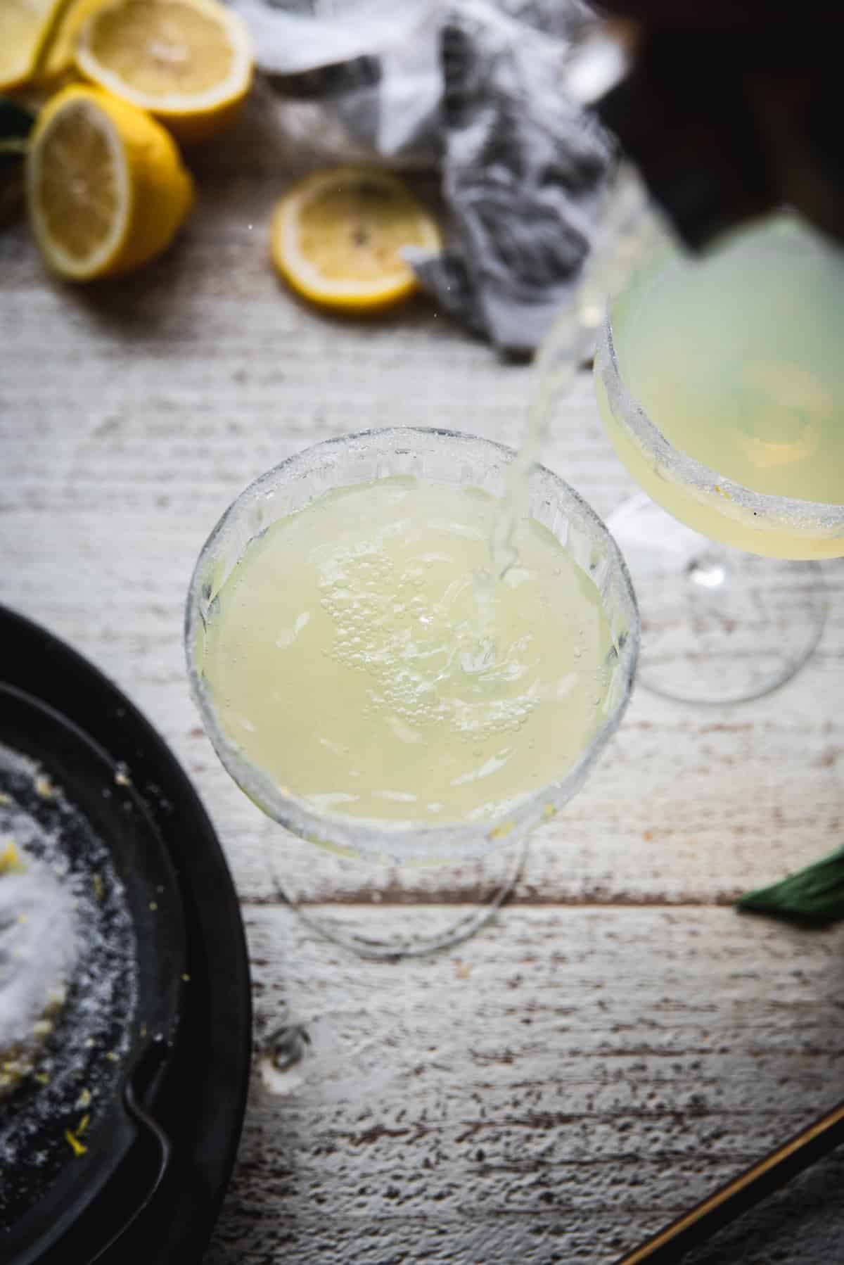 POV pouring limoncello martini into a martini class