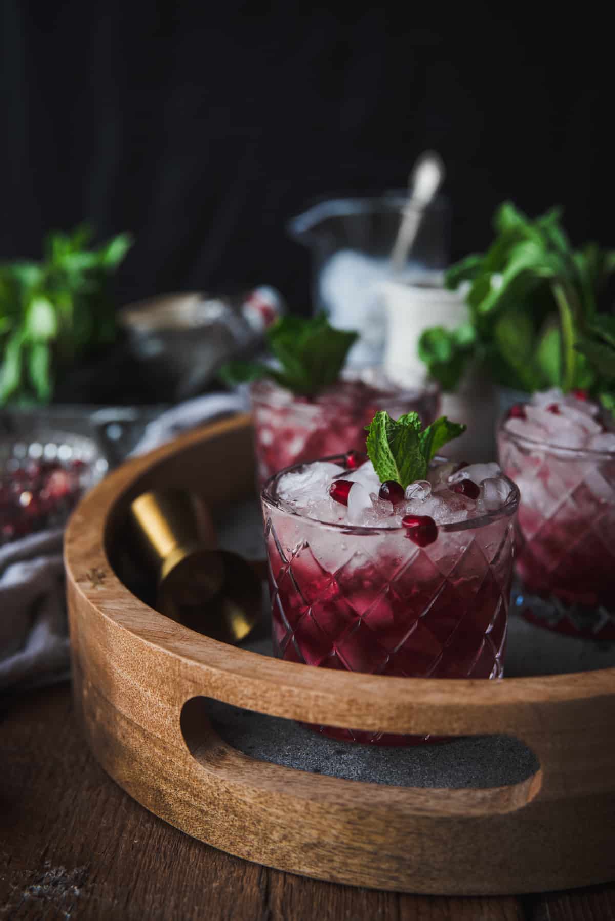 side angle close up on pomegranate mojito topped with somegranate seeds and fresh mint