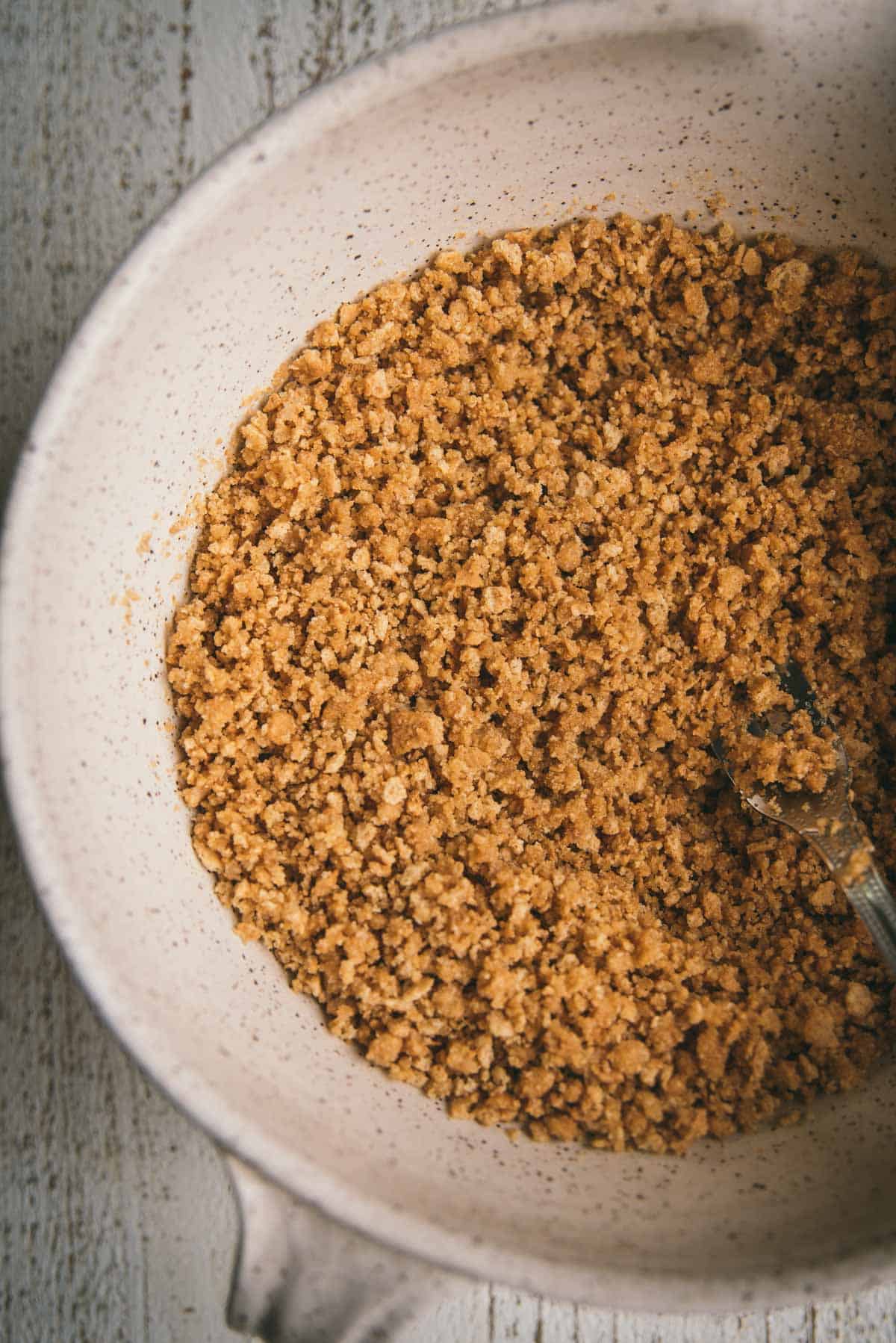 butter coated graham cracker crumbs in a mixing bowl