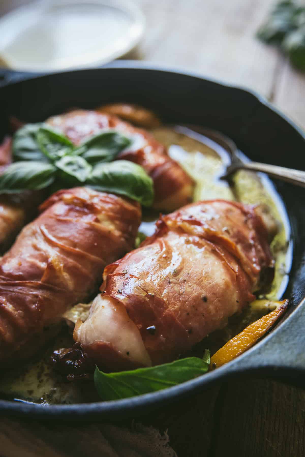 backlit photo of cooked chicken and sauce in cast iron skillet