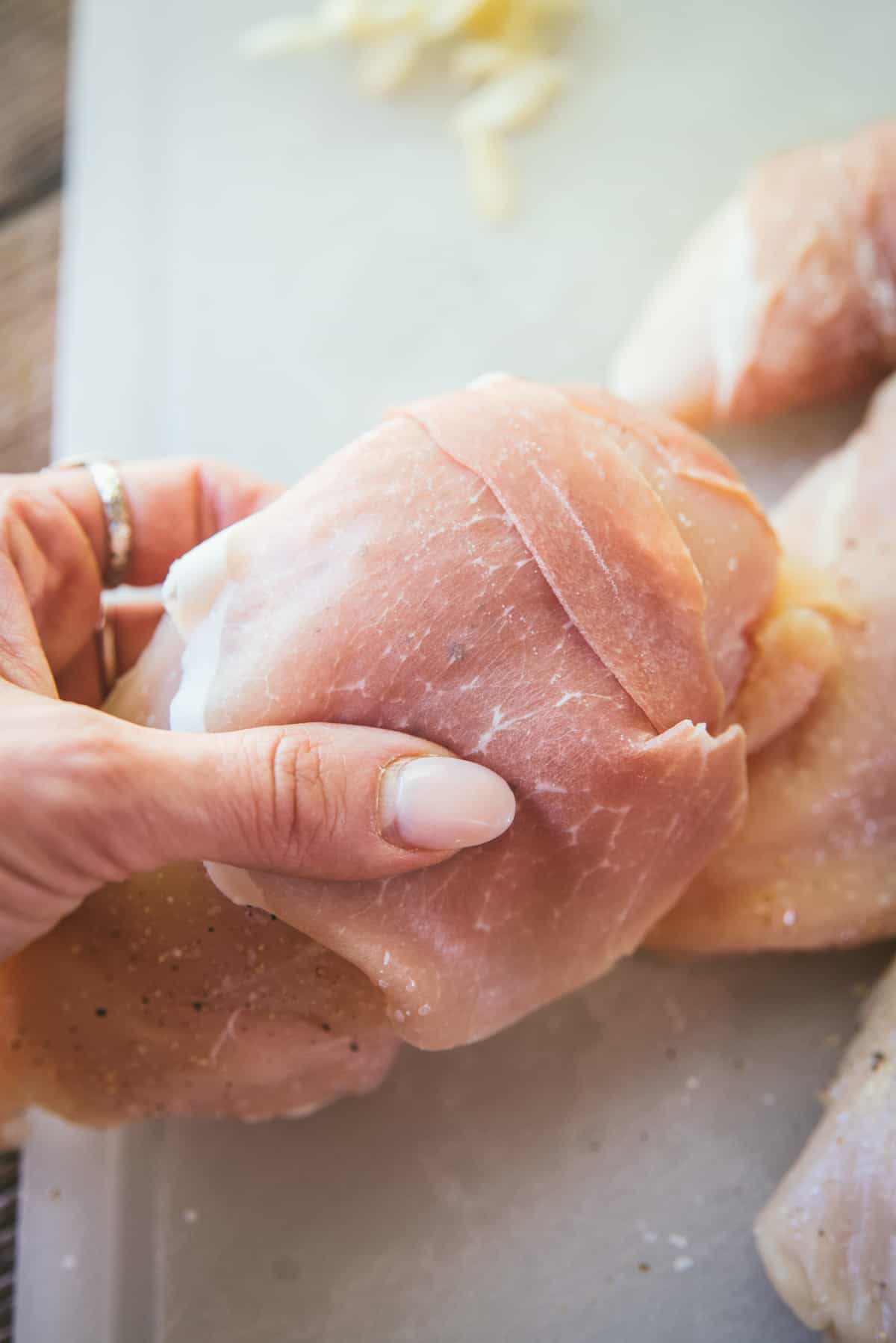 wrapping chicken breast with prosciutto