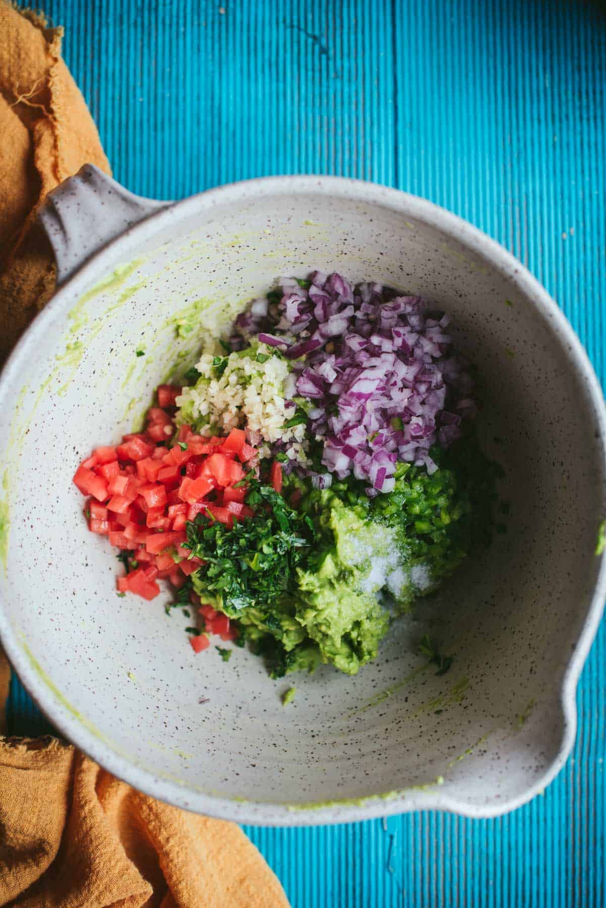 All the other ingredients are finely chopped and added to the bowl, except the lobster. Chopped onion, tomato, cilantro and garlic are added.