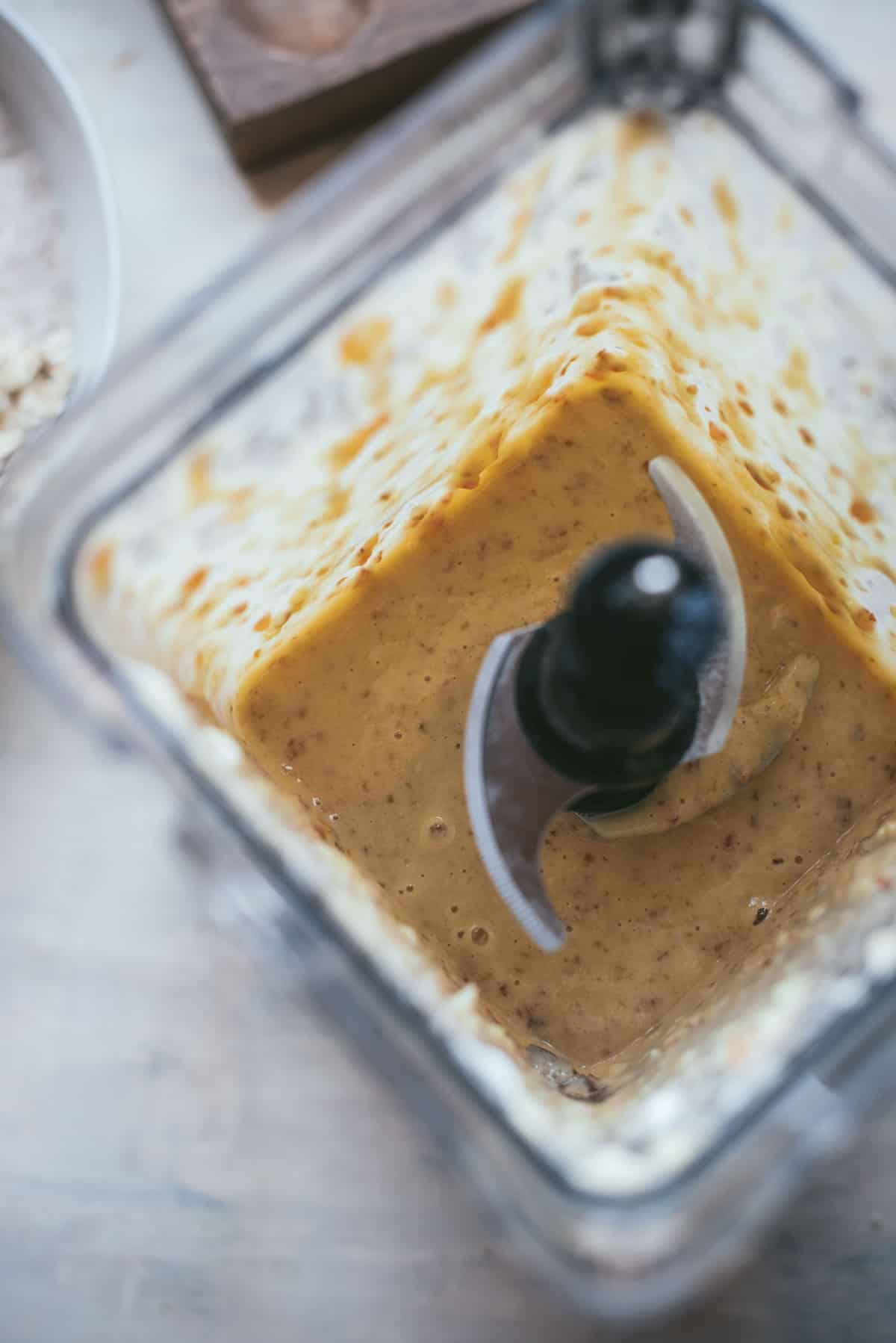 Looking through the top of a blender with no lid, you can seea blended cream color batter.
